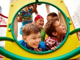 The children are happily playing on the playground.